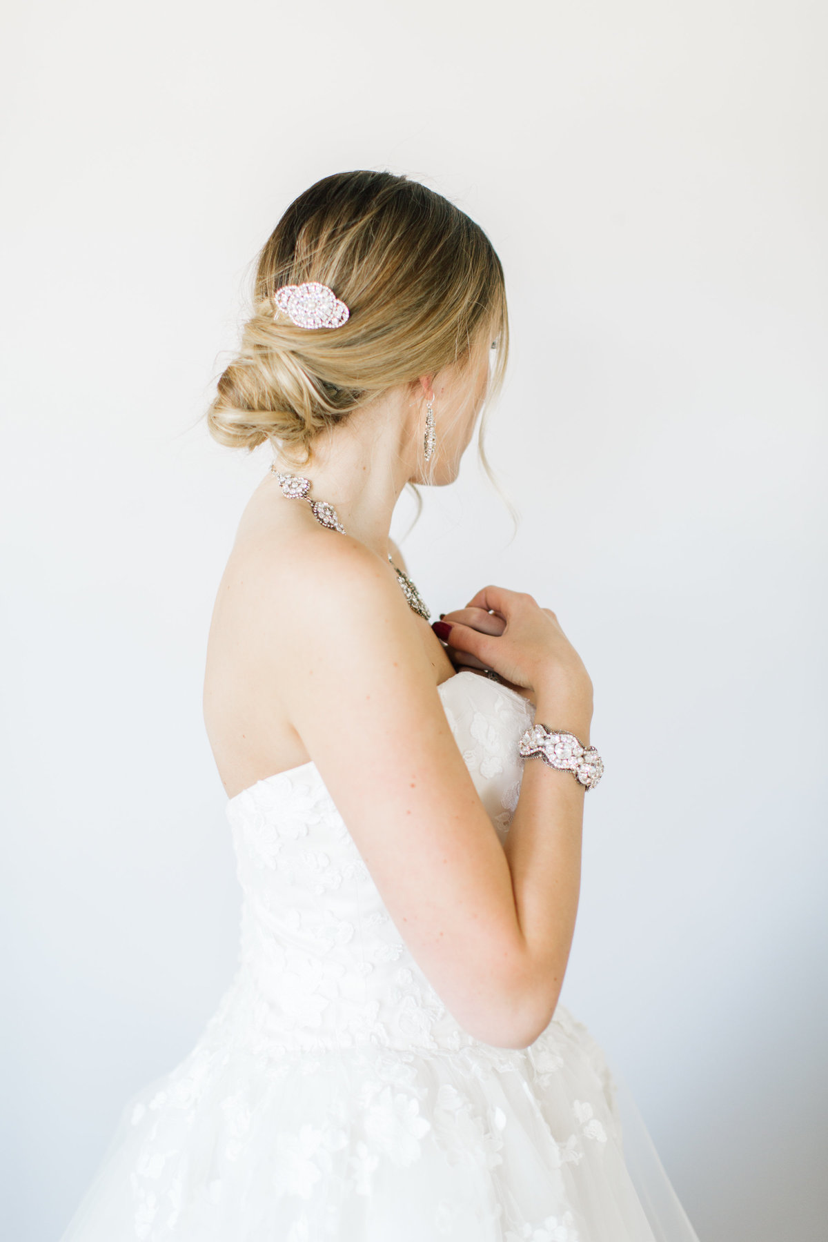 bride looking away with hair pin and bracelet