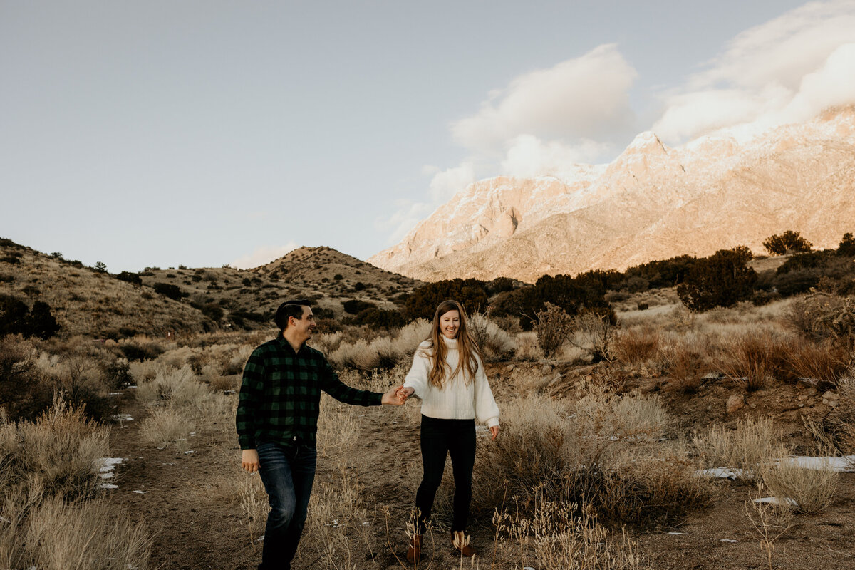 engaged couple walking along the Sandia foothills in Albuquerque