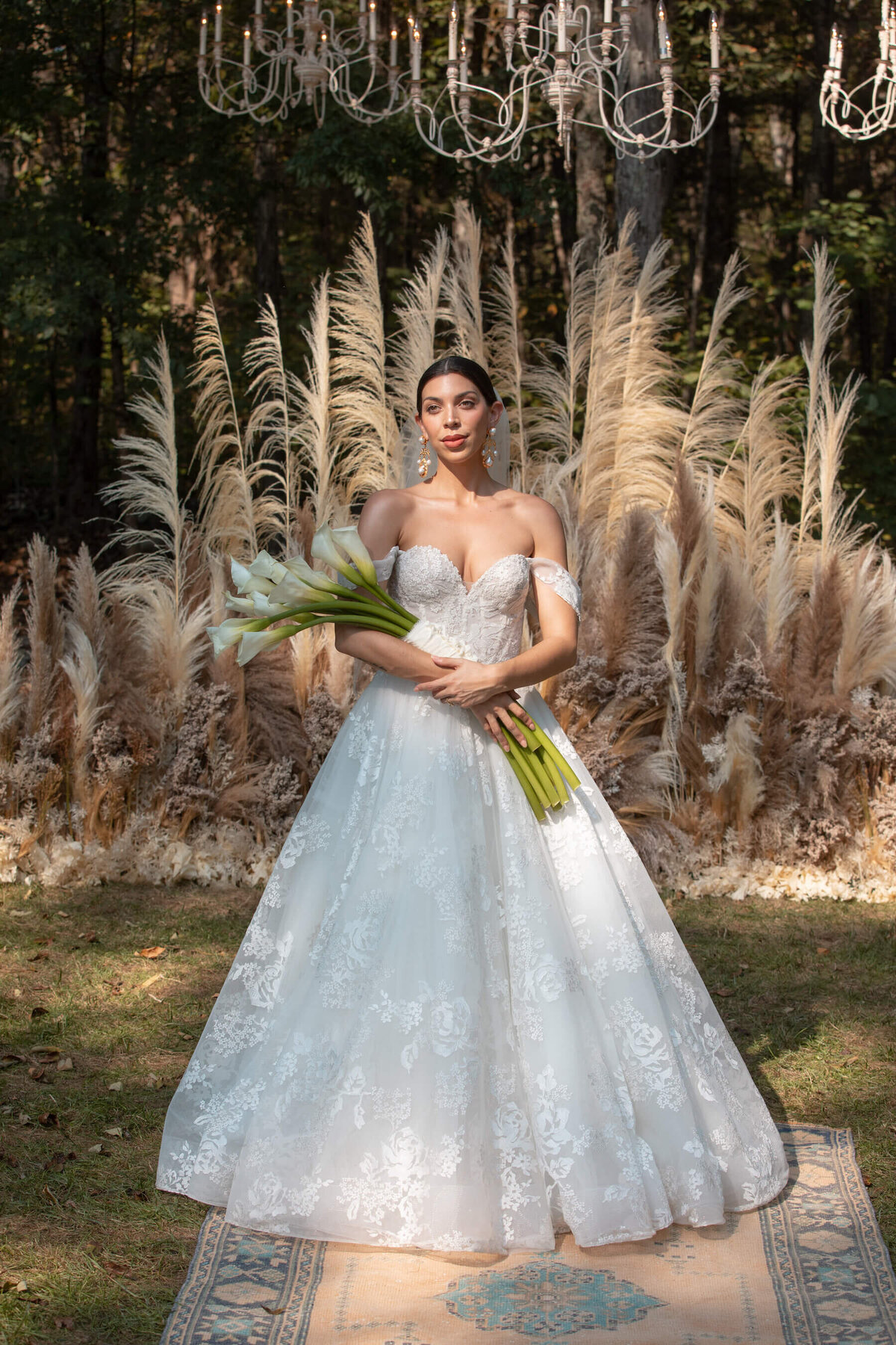 Bride with calla lilly wedding bouquet and pampas grass wedding altar.