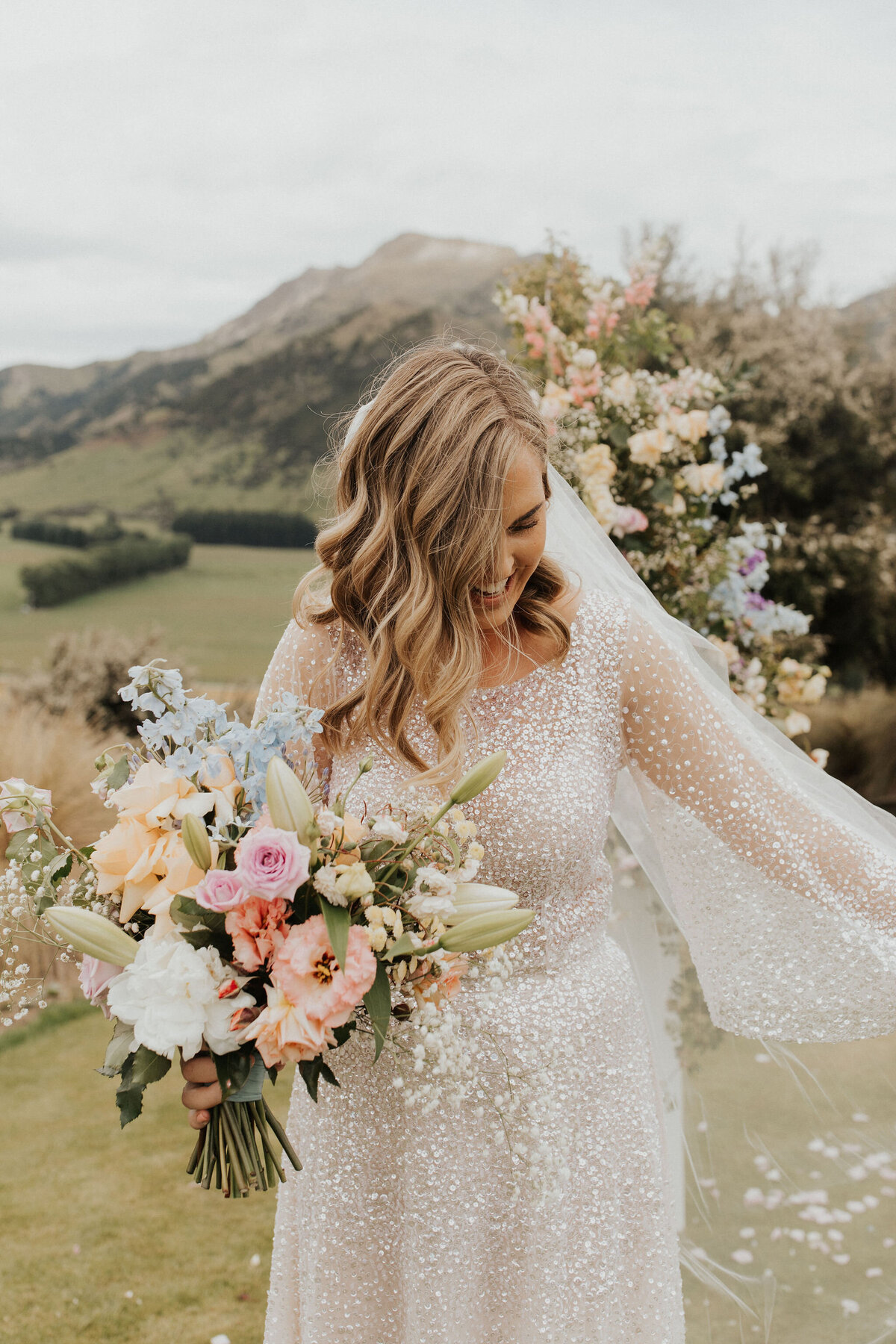 The Vase Floral Co - bride holds pretty bouquet in Queenstown wedding
