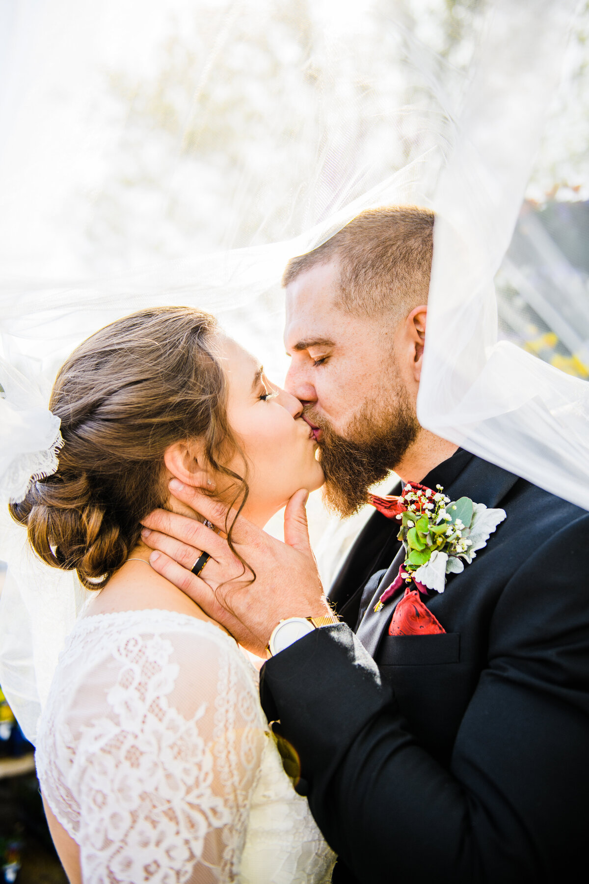 Bride and groom kissing under veil sunlight golden hour Flagstaff The Gardens at Viola's Wedding