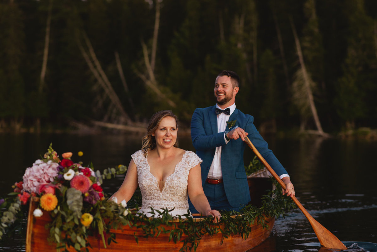 bride and groom canoeing at sunset on a lake