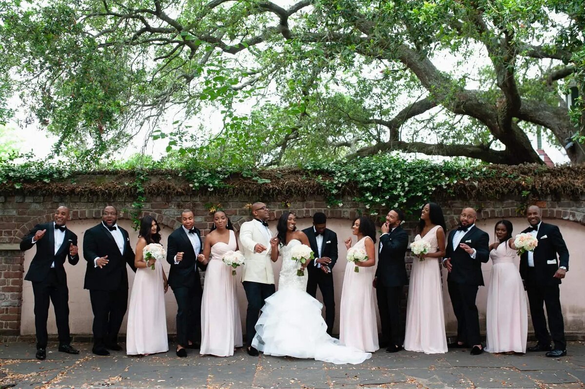 A wedding couple standing together with their wedding parties.