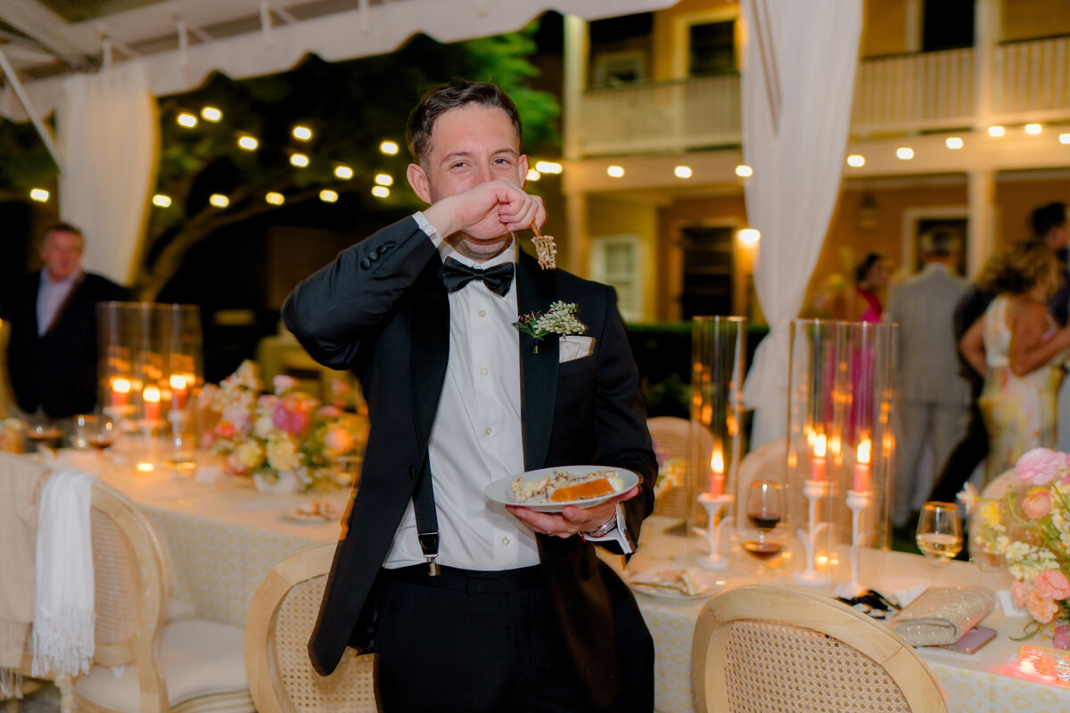 candid photo of groom trying to eat cake.