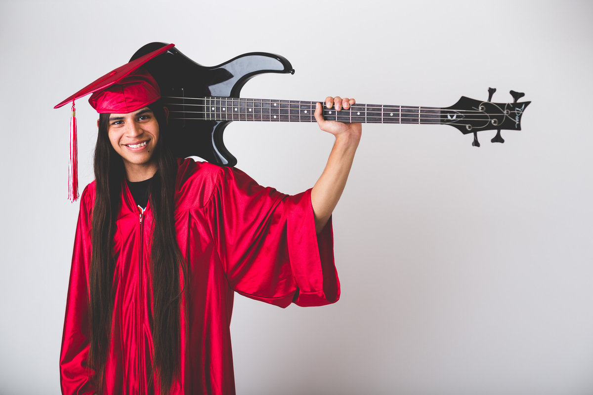 high school senior session of guy in cap and  gown with guitar by San Antonio senior photographer