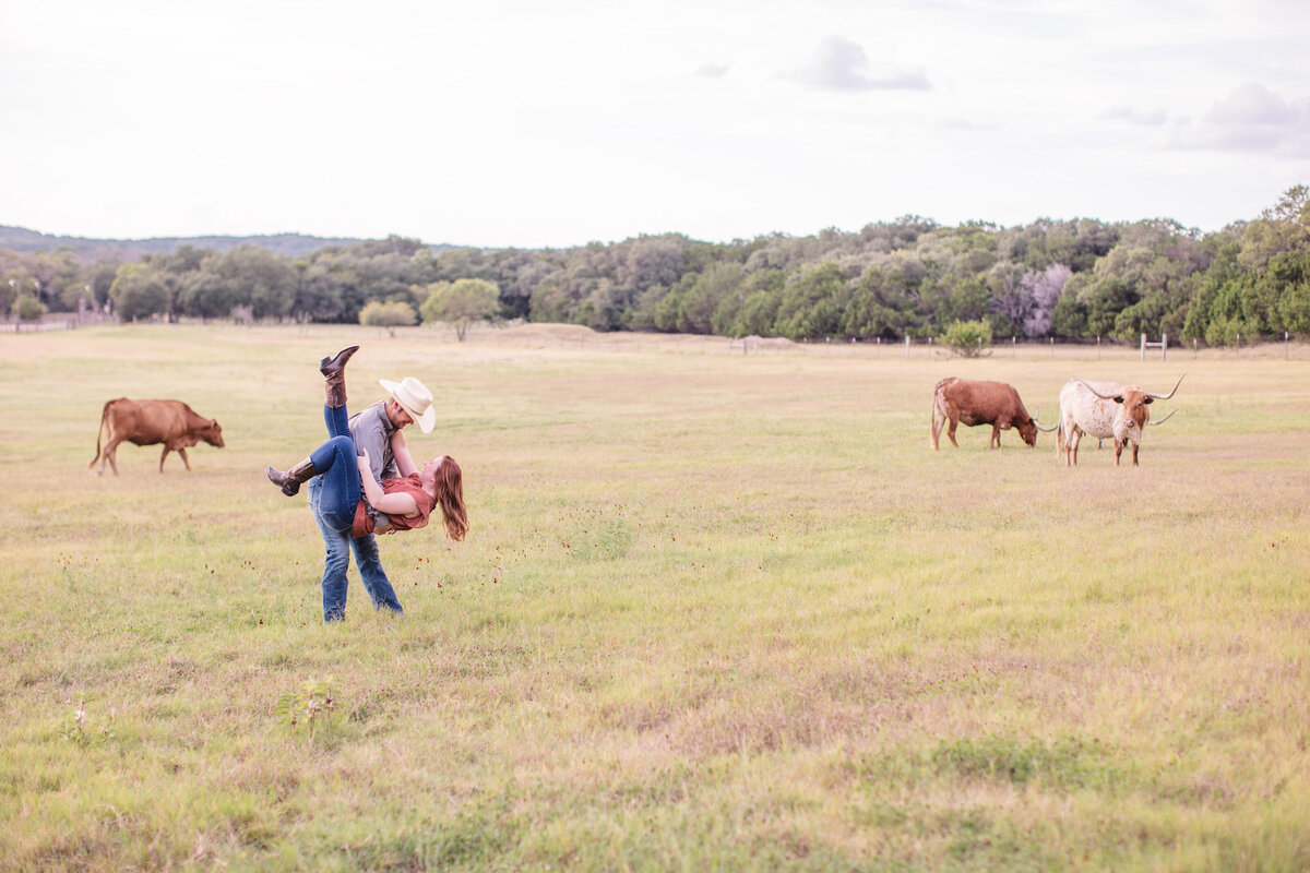 Texas wedding engagement session dancing in pasture with longhorns in Boerne by Firefly Photography
