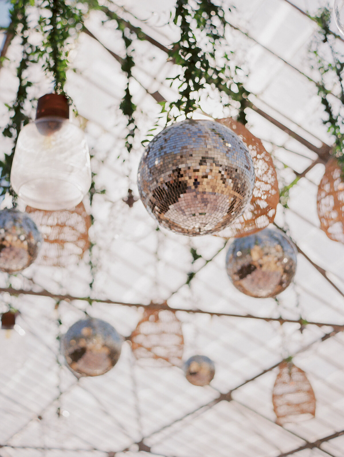 disco balls and hanging rattan chandeliers from greenhouse