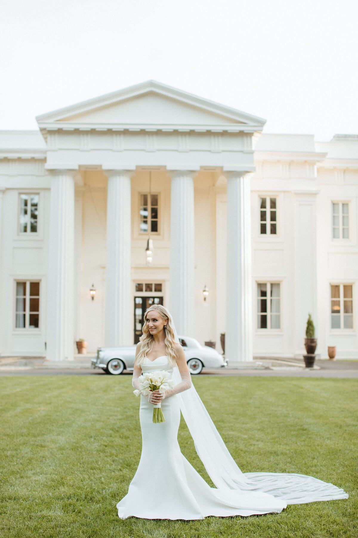 bride holding bouquet in front of wedding venue