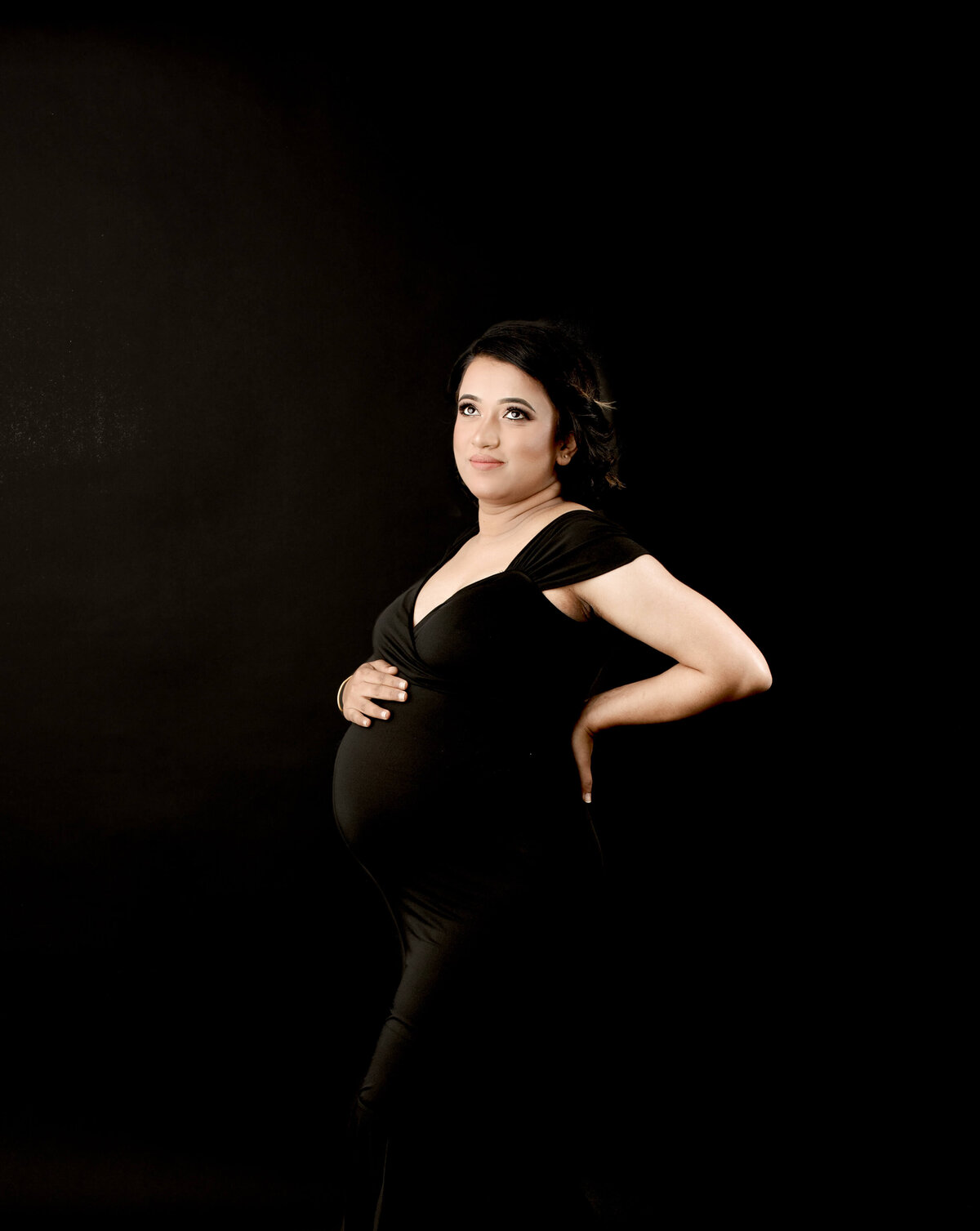 Maternity Photoshoot with mum-to-be in a black maternity gown on a dark backdrop for a maternity photoshoot by  Lauren Vanier Photography