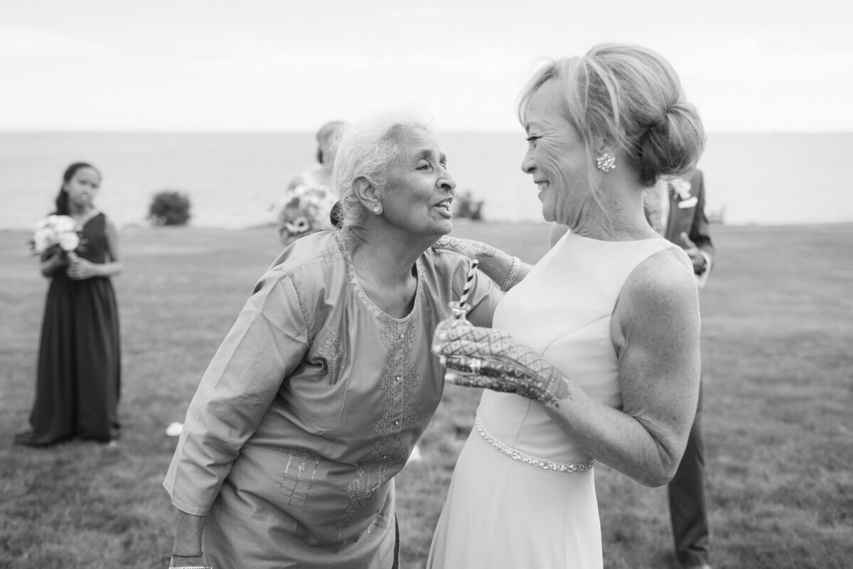 mother of bride and grandma laugh together - gold shoes and wedding details - branford house wedding