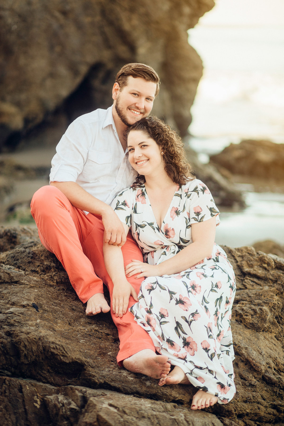 Engagement Photograph Of  Man And Woman Seated On a Rock Los Angeles