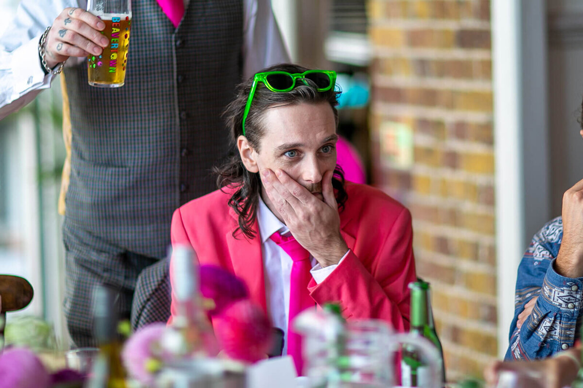 Best man in pink suit at dinner table at Thames Rowing Club