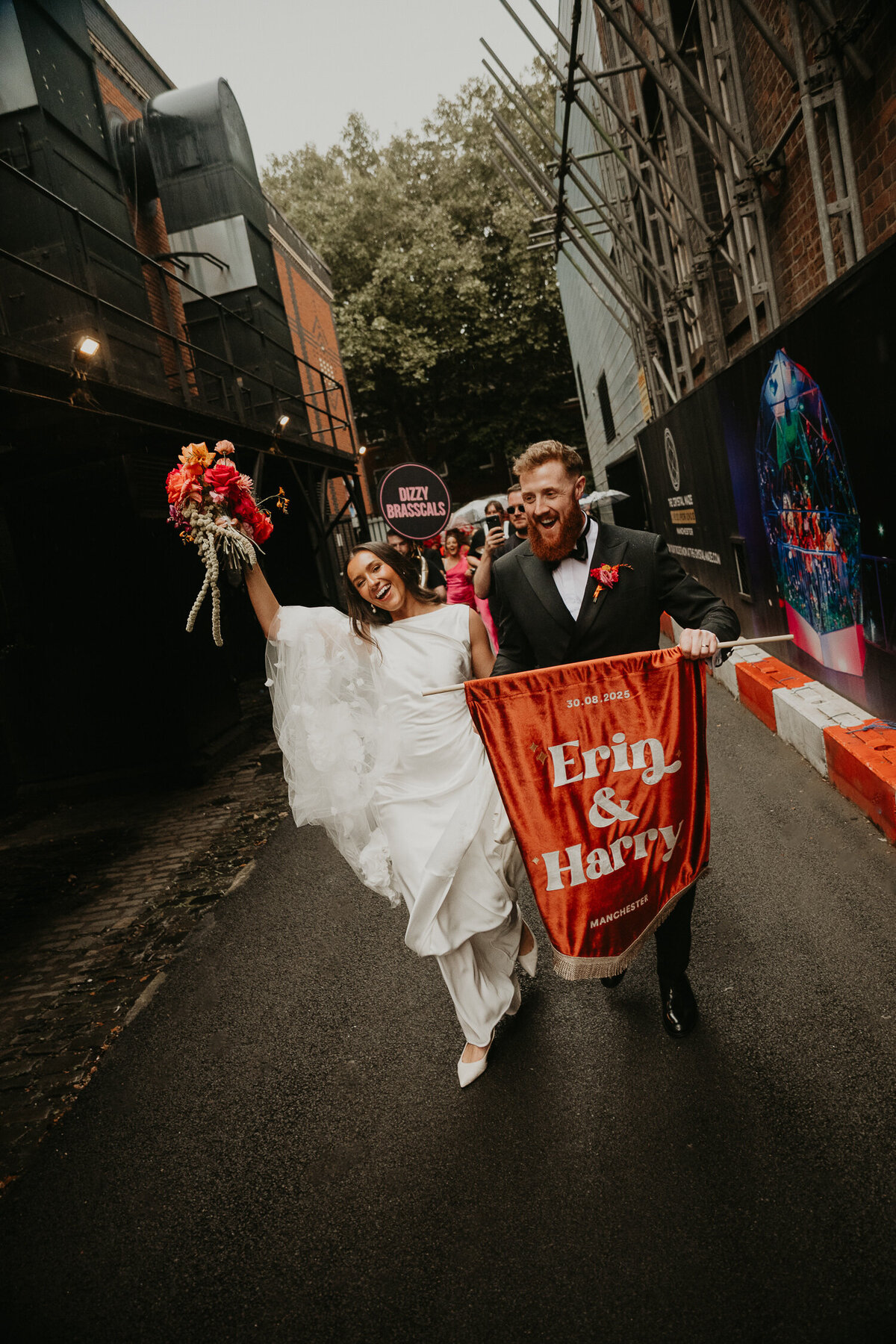 Bride and groom carry a custom wedding banner from The Dome at ABC Buildings in Manchester. 