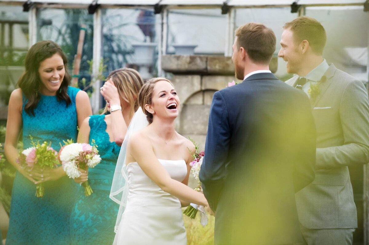 a bride and bridesmaids laugh during a wedding ceremony at castaway pdx
