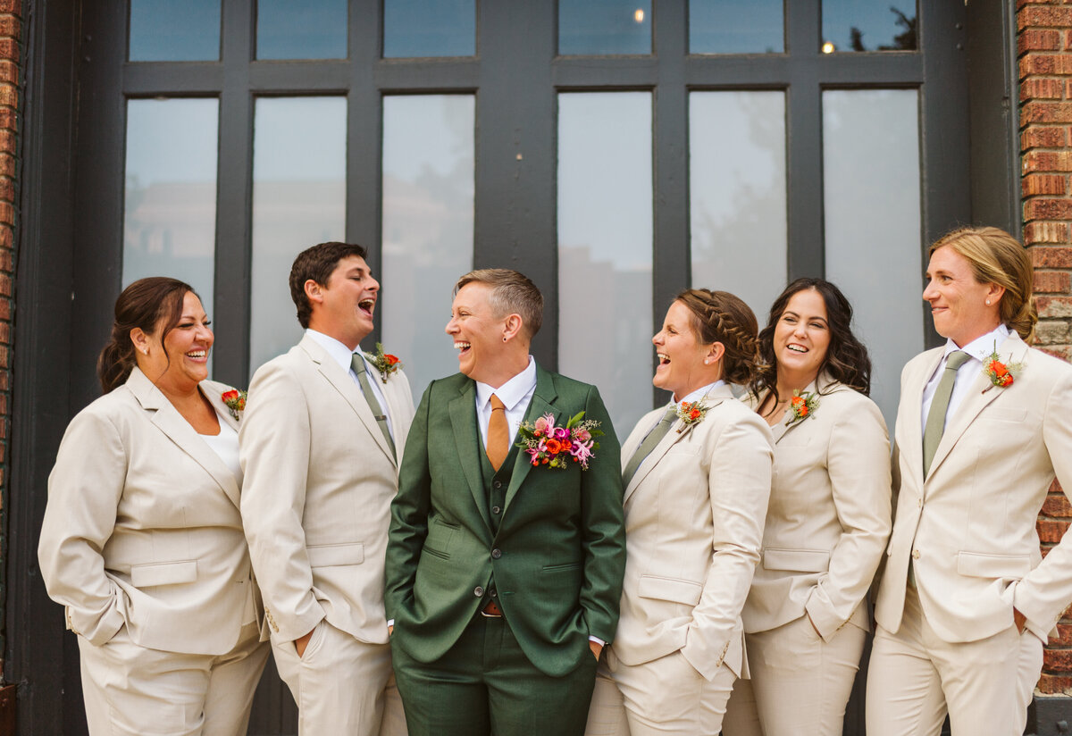 Groom in green suit with groomsmen in cream suits at the St Vrain, Boulder county wedding venue