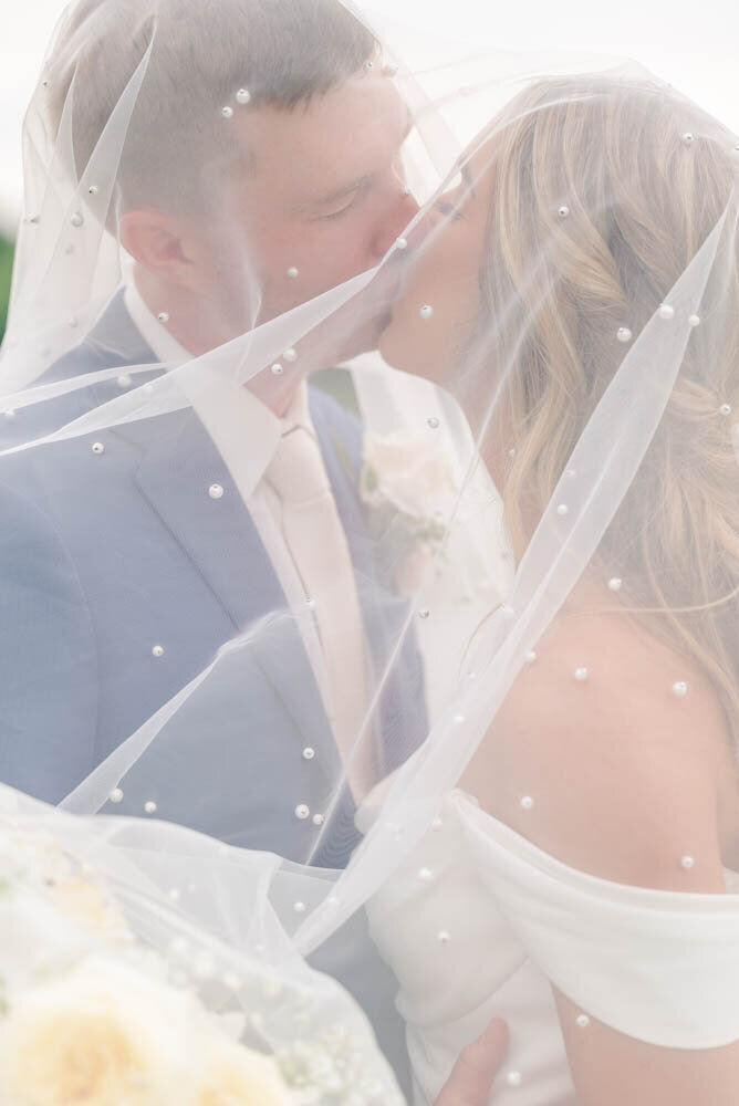bride-and-groom-kissing-behind-veil