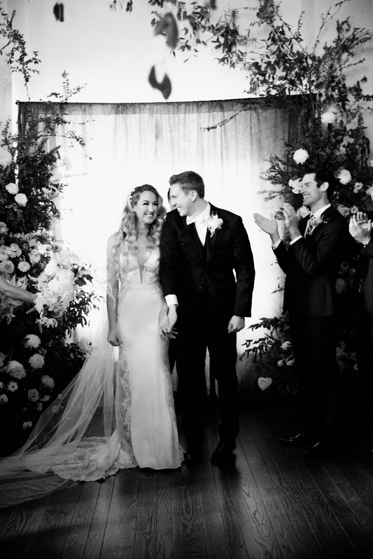 bride and groom under a full arch of flowers