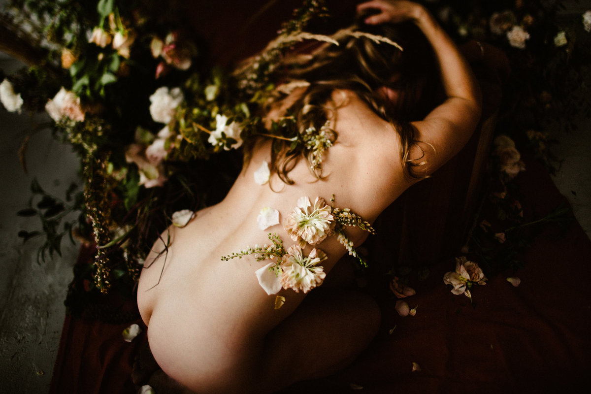 woman surrounded by tanya val flowers with florals on her body