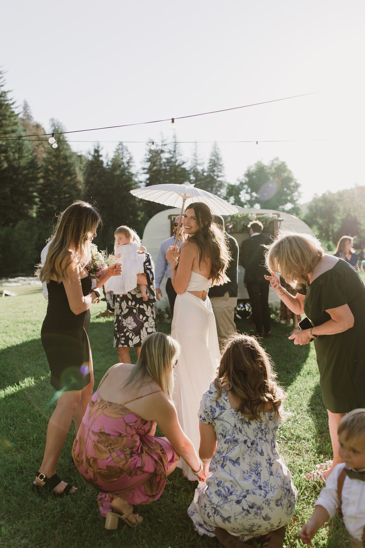 Women surrounding bride as they fan out her dress