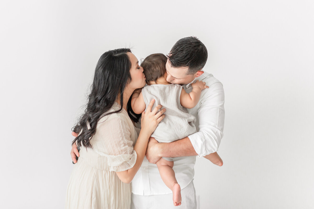A Baby Photography in Northern Virginia mother and father kissing their baby boy