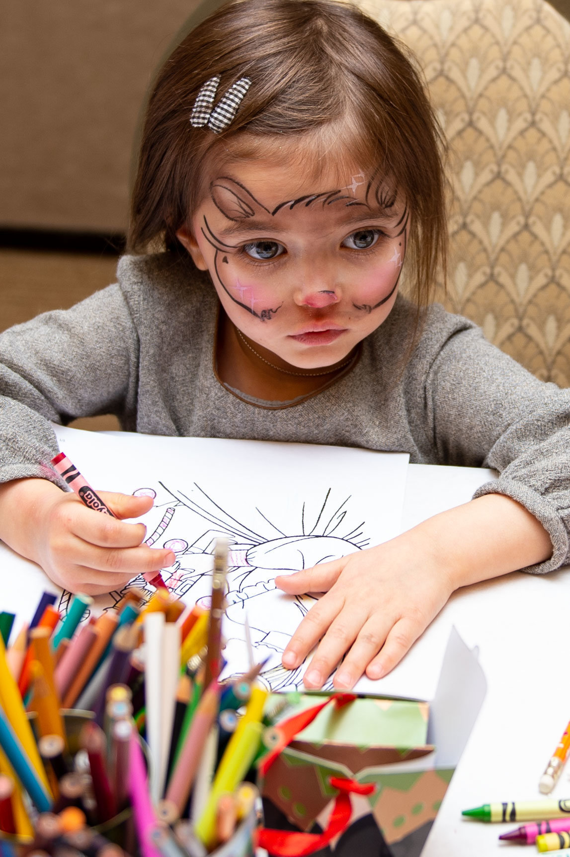 young girl with face paint coloring