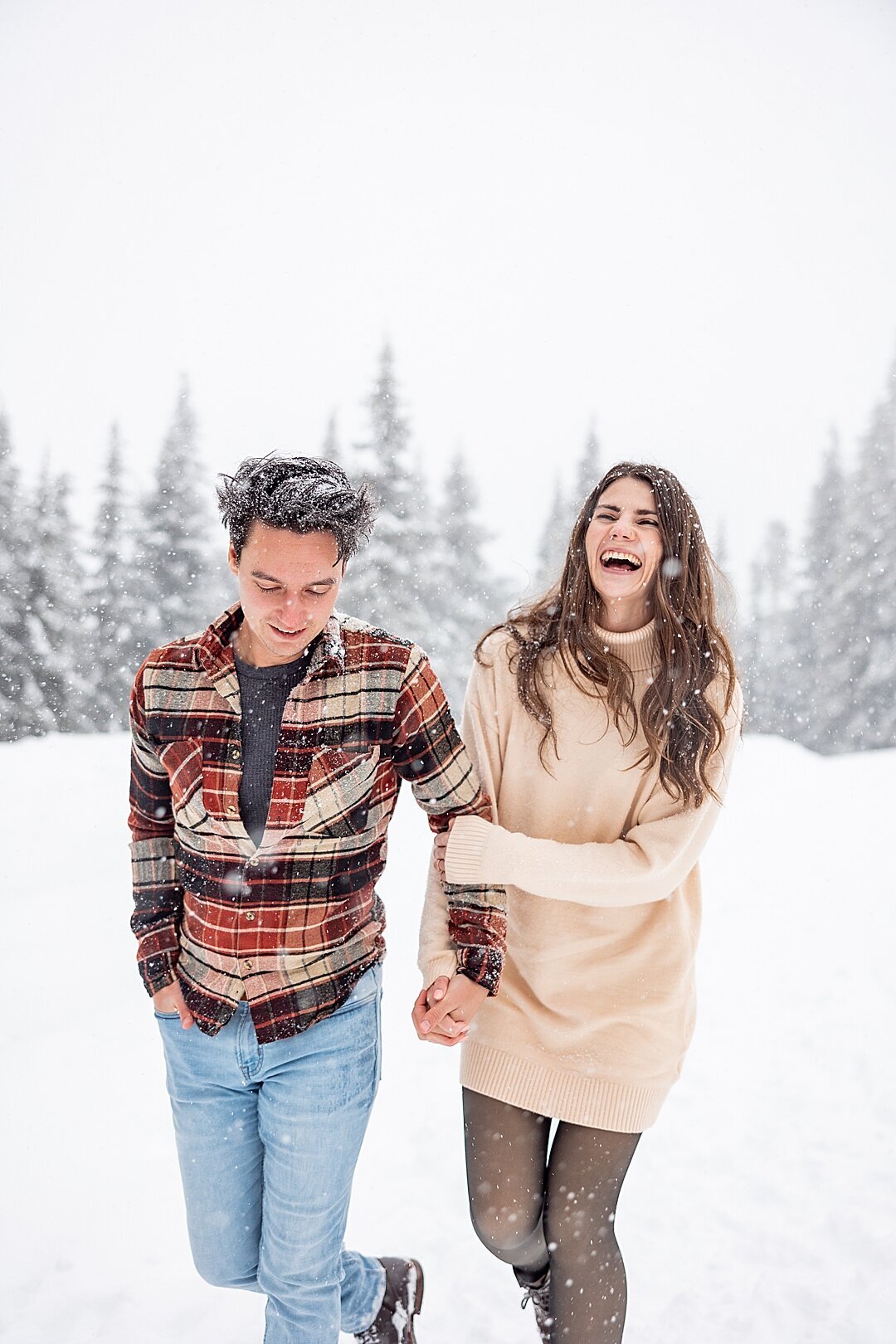 couple in the snow laughing with snow in their hair