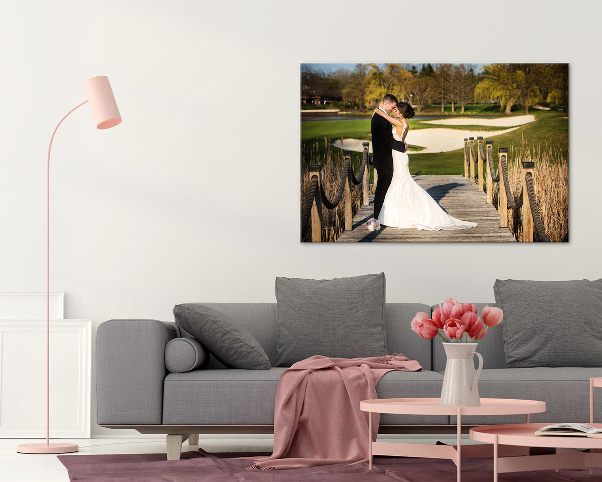Large wedding canvas in a living room with stylish sofa and small pink table.
