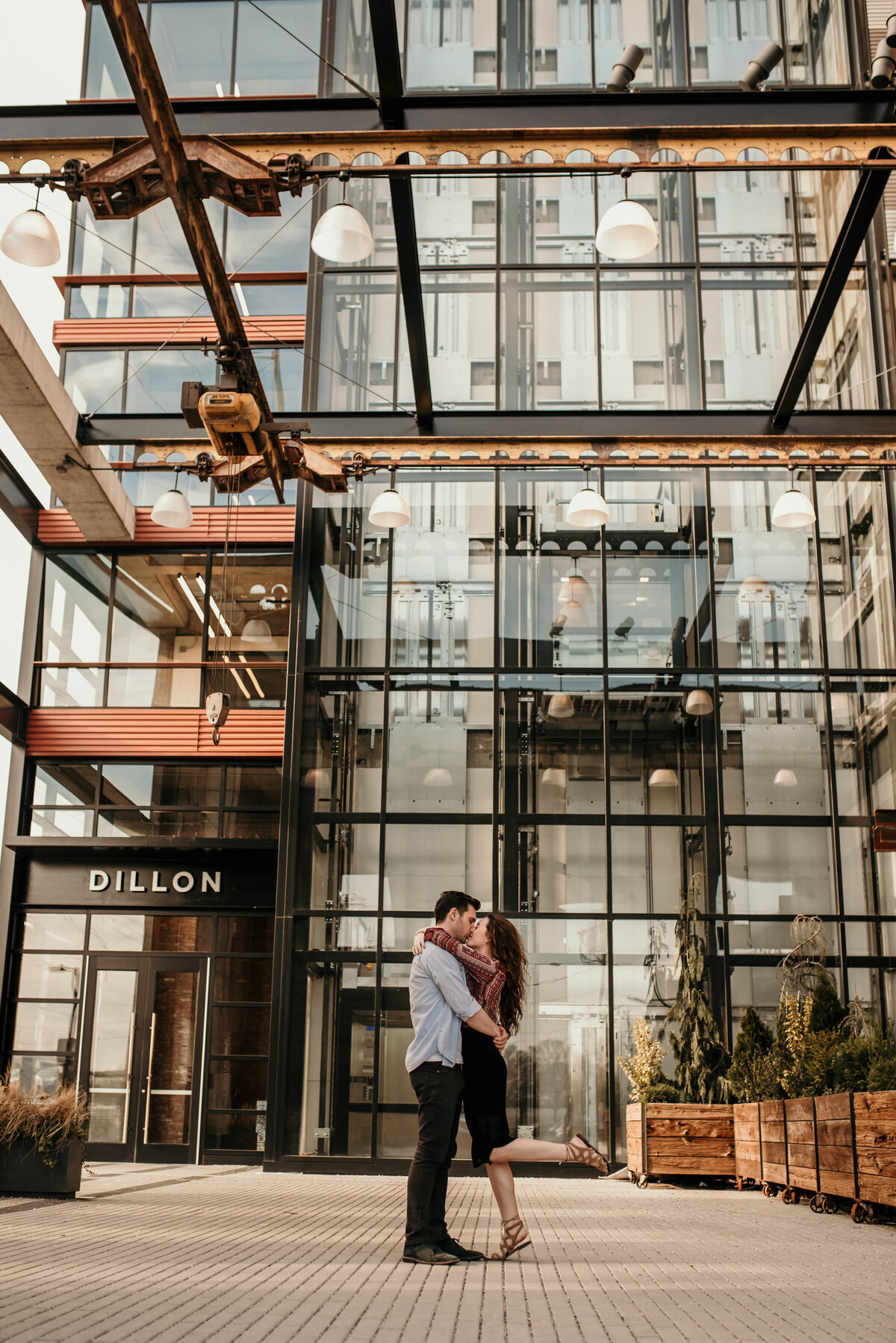 A couple kisses in front of a building