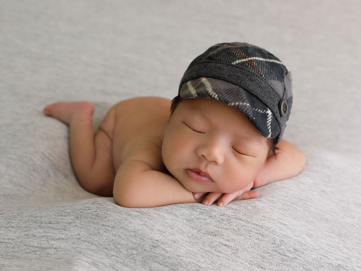 Newborn-photography-session-newborn-in-classic-newborn-photograhy-pose-with-newborn-hat,-photo-taken-by-Janina-Botha-photographer-in-Burlington-Ontario