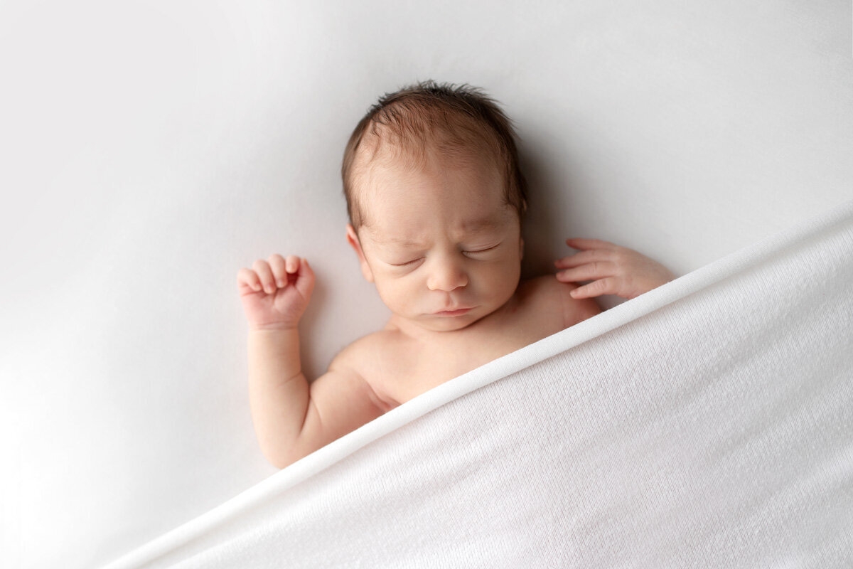 Newborn session of baby boy under sheet