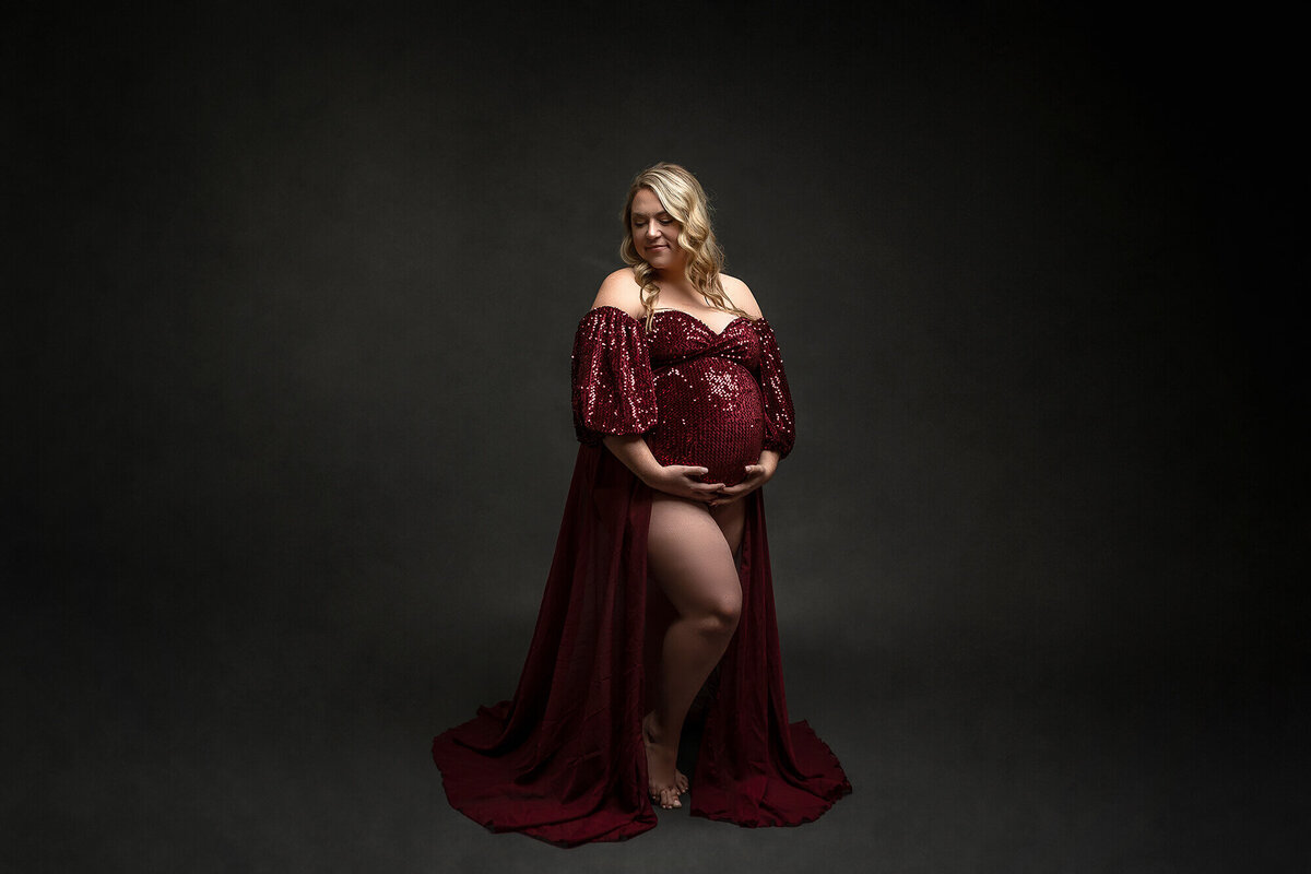 Expecting mother wearing a beautiful red sequenced gown.