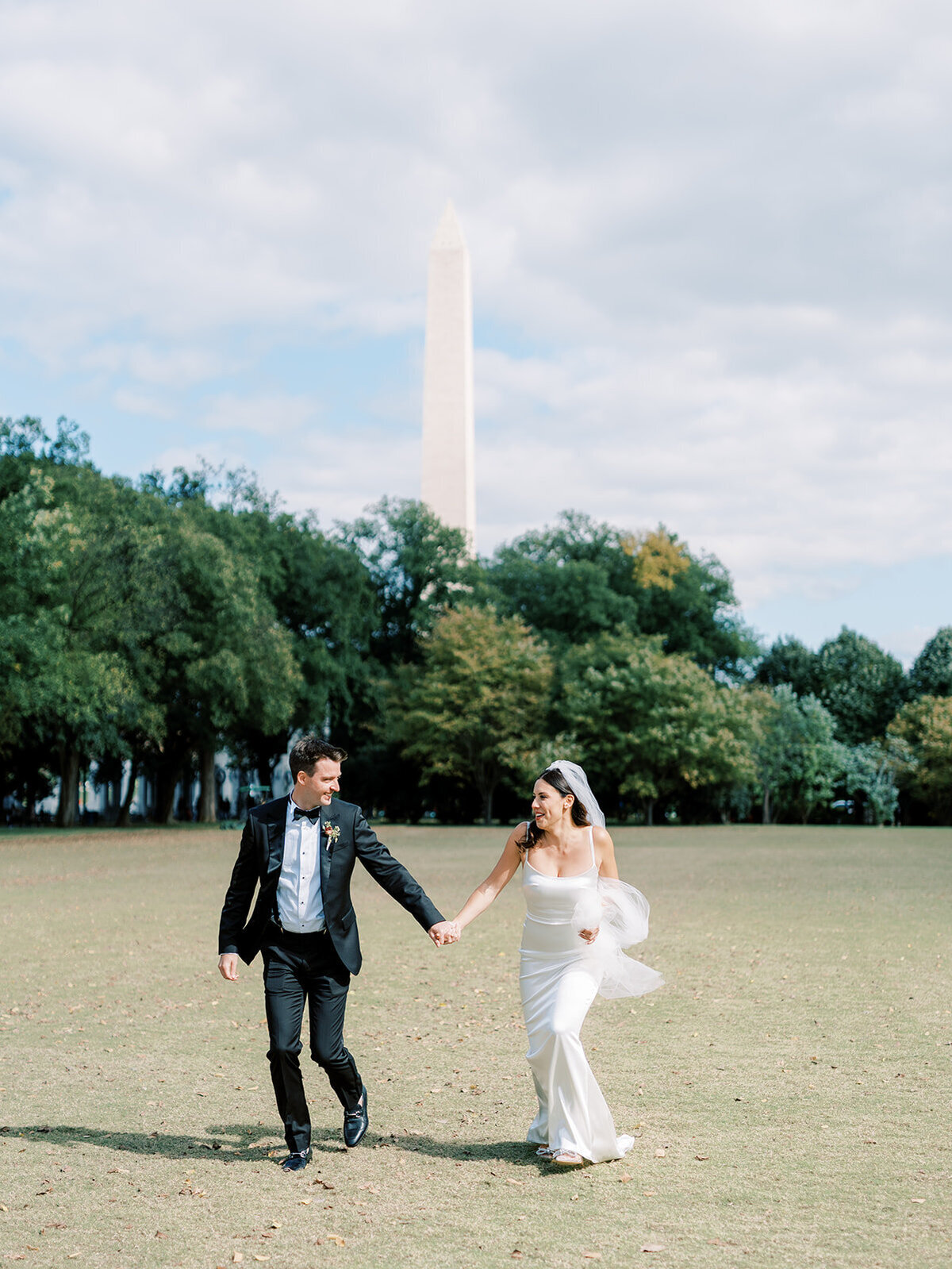 Bride and groom running through the national mall