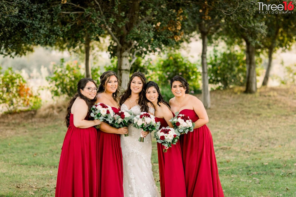 Bride and her Bridesmaids posing in the field together