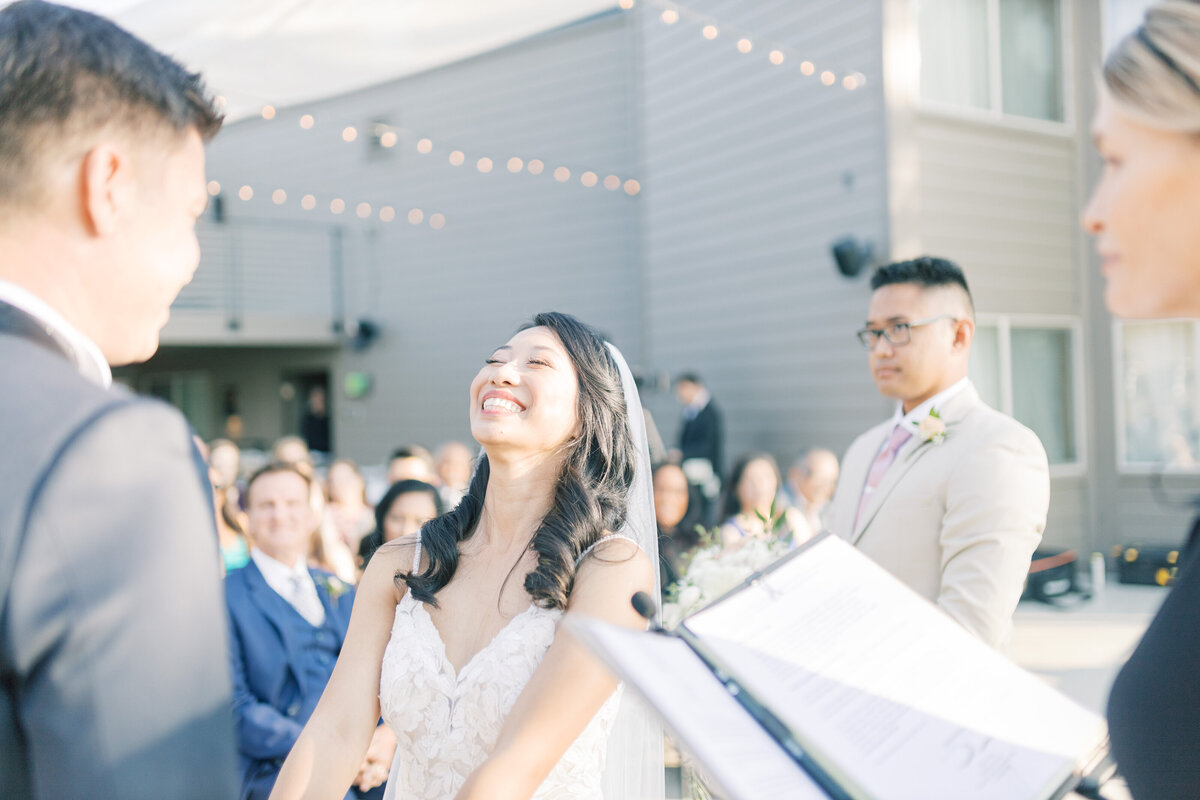 Bride smiles joyfully during her wedding vows