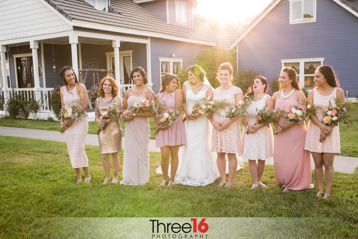 Bride poses with her Bridesmaids as they share a laugh