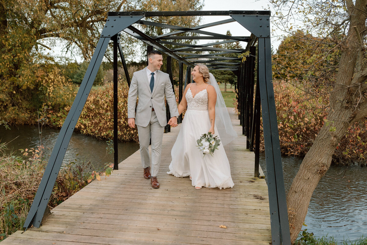 bride and groom walking together in the autumn