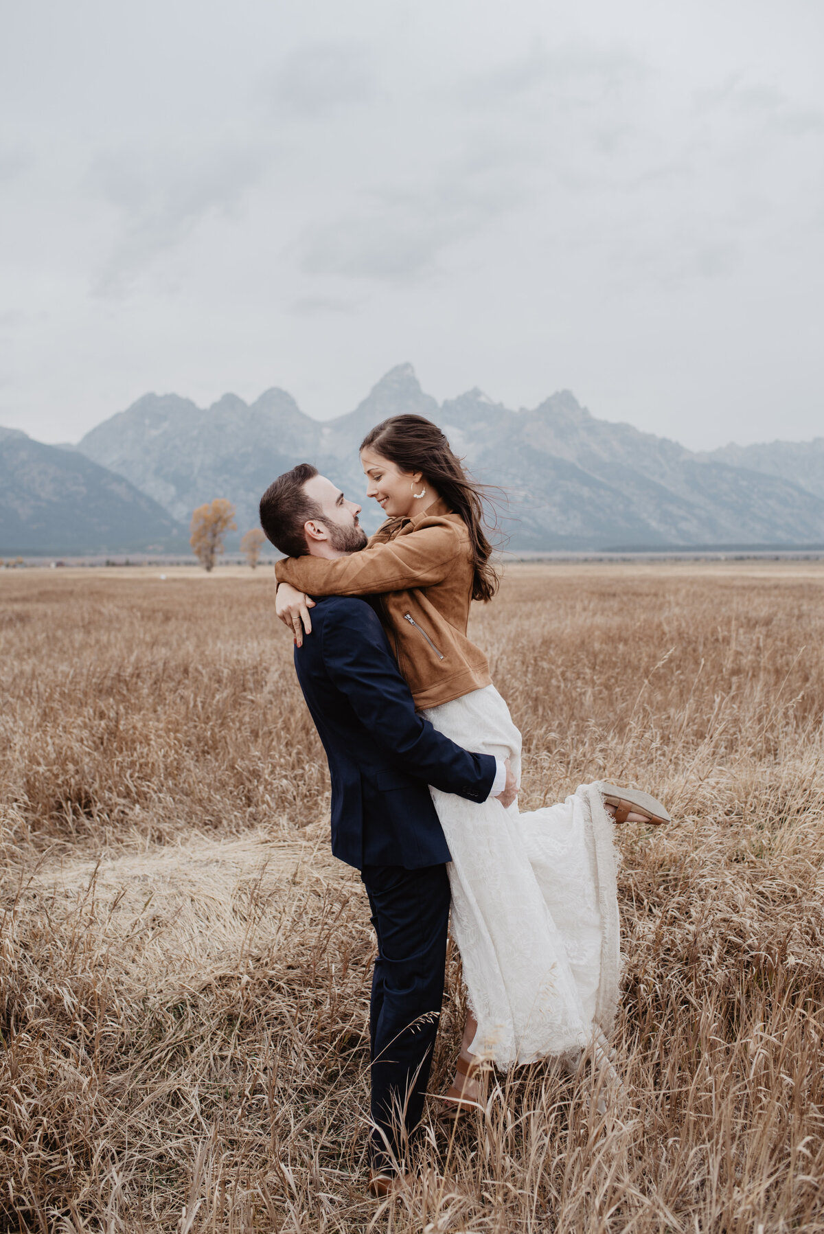 Photographers Jackson Hole capture groom lifting bride and holding her
