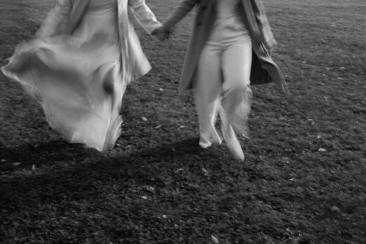 brides running in blurry black and white photo
