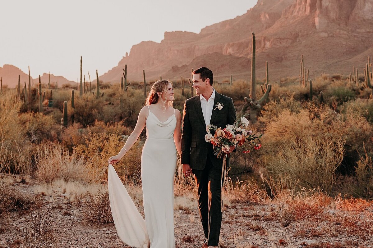 Phoenix wedding couple walk through desert at sunset