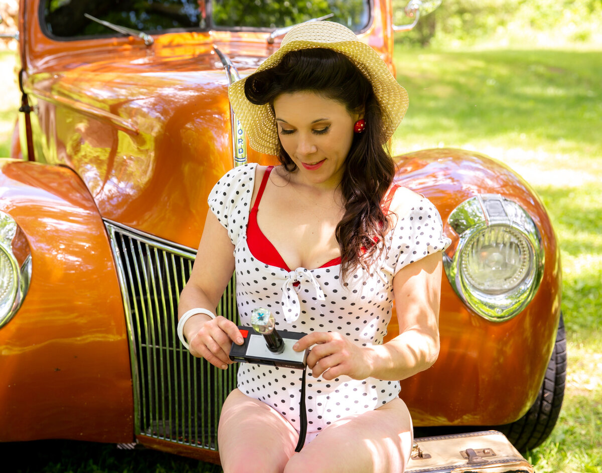 goddess studio boudoir woman pinip style old ford pickup beach hat polka dot bodysuit with red bra vintage camera