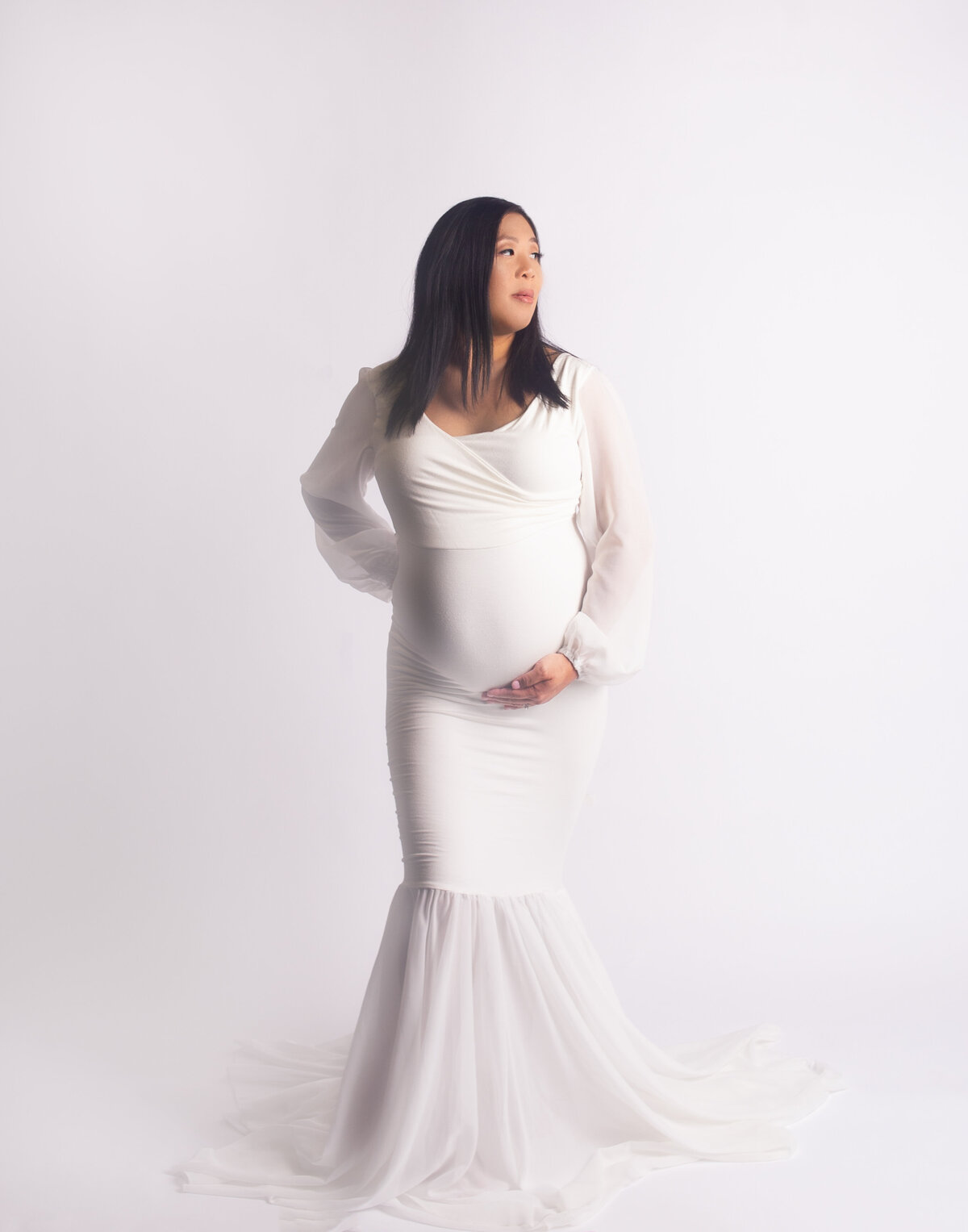 Wonen wearing white gown with glam makeup during maternity photoshoot in Franklin Tennessee photography studio