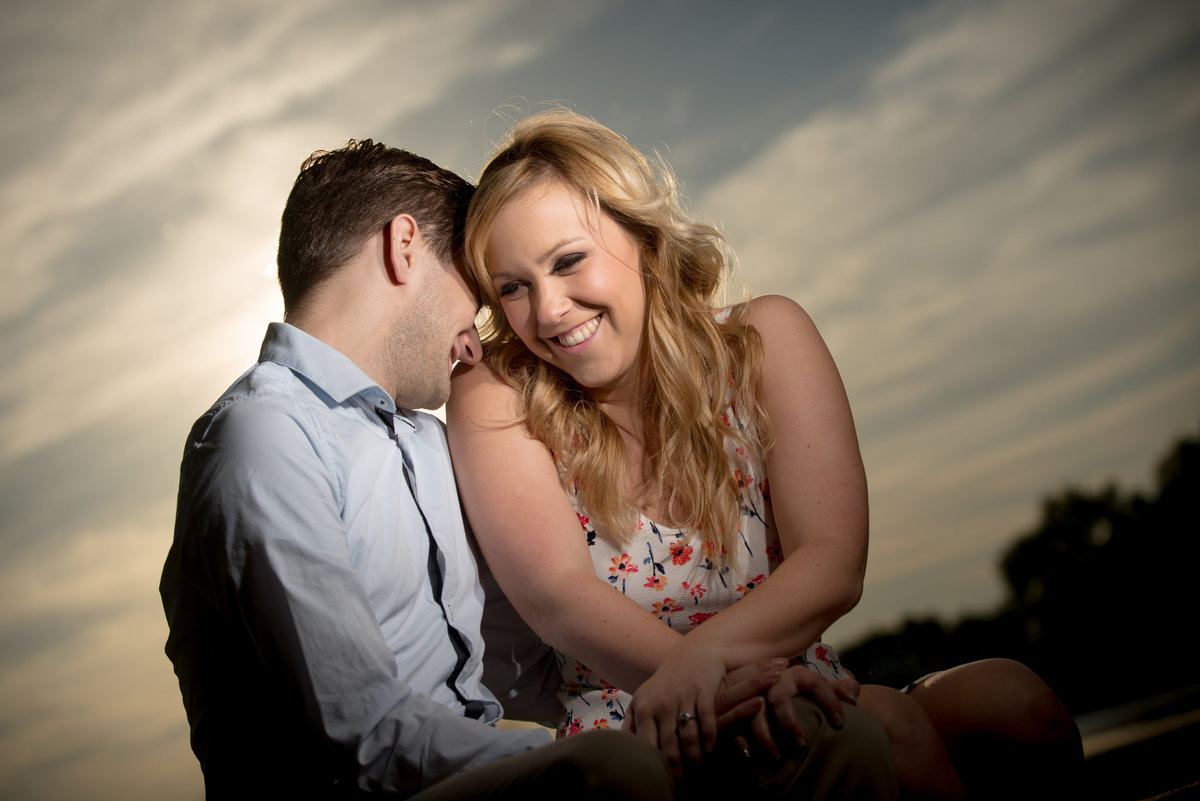 Playful giggling engagement couple at sunset