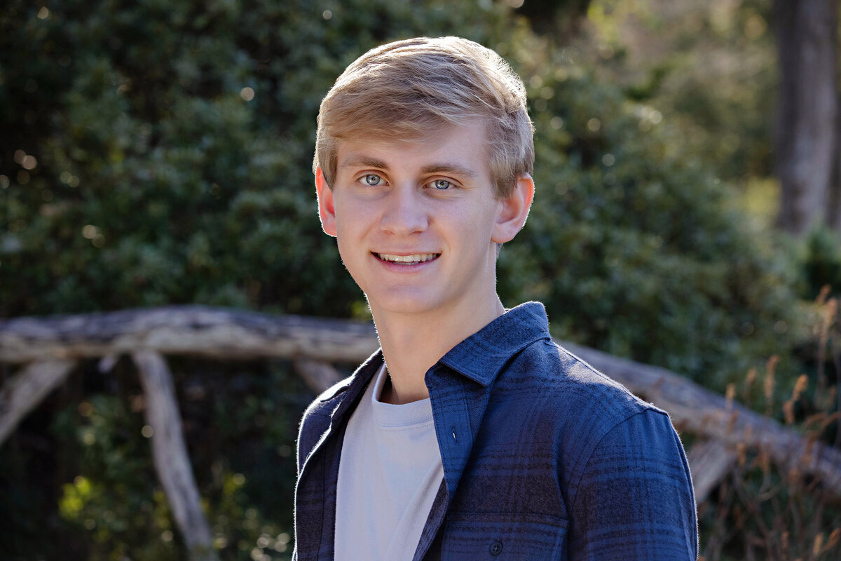 Striking fall portrait of college freshman framed by lush foliage at UNCC Botanical Garden Charlotte NC