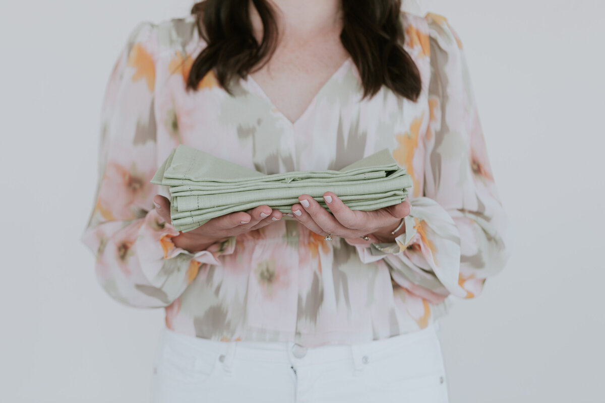 detail-photo-event-planner-hands-holding-napkin-stack-for-brand-session-the-frame-charlotte
