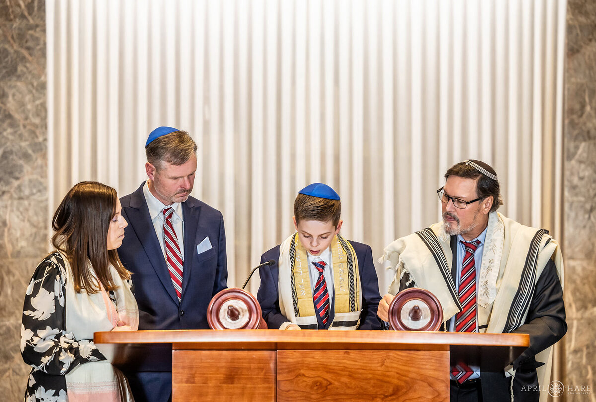 Jewish Boy Reads from the Torah with his Rabbi and Parents Surrounding Him at Temple Sinai in Denver Colorado