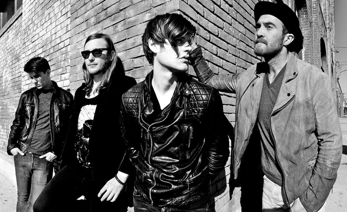 Rock band portrait The Filthy Souls black and white leaning against brick wall