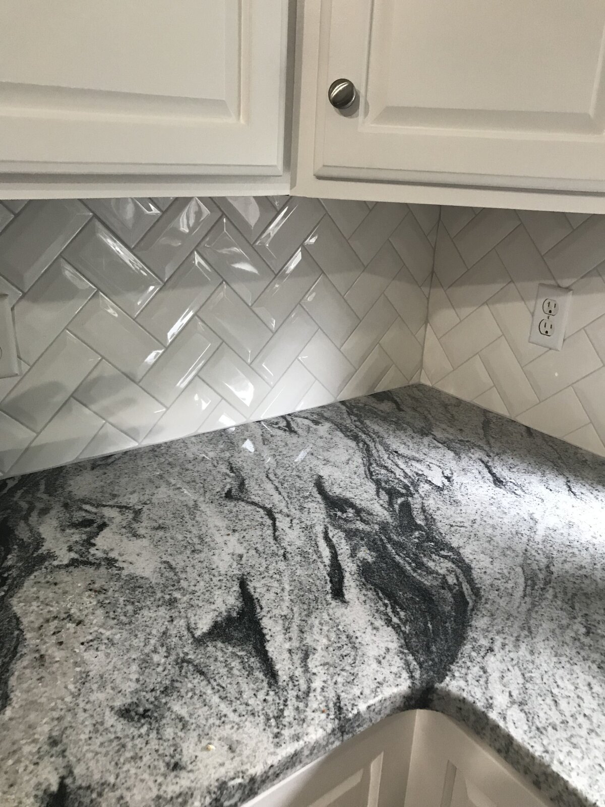Viscount White granite countertops with a chevron beveled subway tile and cabinets painted in Sherwin Williams “Snowbound”_