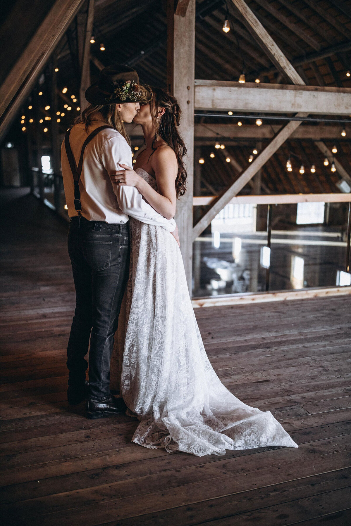 Couple standing on upper balcony at Countryside Barn, rustic, country Lethbridge, Alberta wedding venue, featured on the Brontë Bride Vendor Guide.