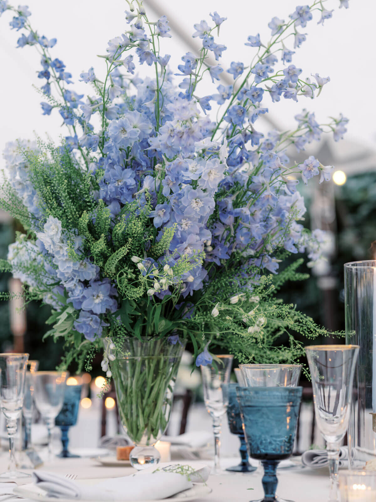 A gorgeous blue flower centerpiece on an elegant wedding dining table at Lion Rock Farm, CT. Image by Jenny Fu Studio