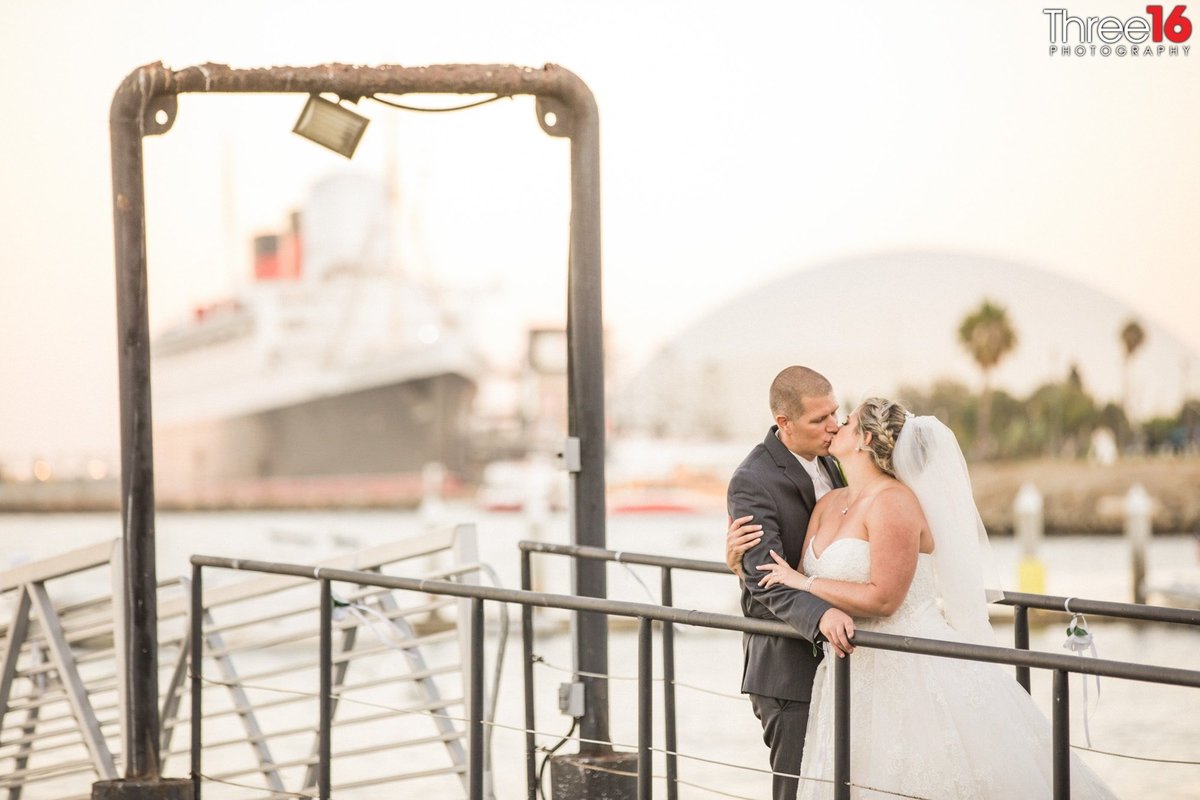 Bride and Groom share an intimate kiss on the boat docks during a photo session